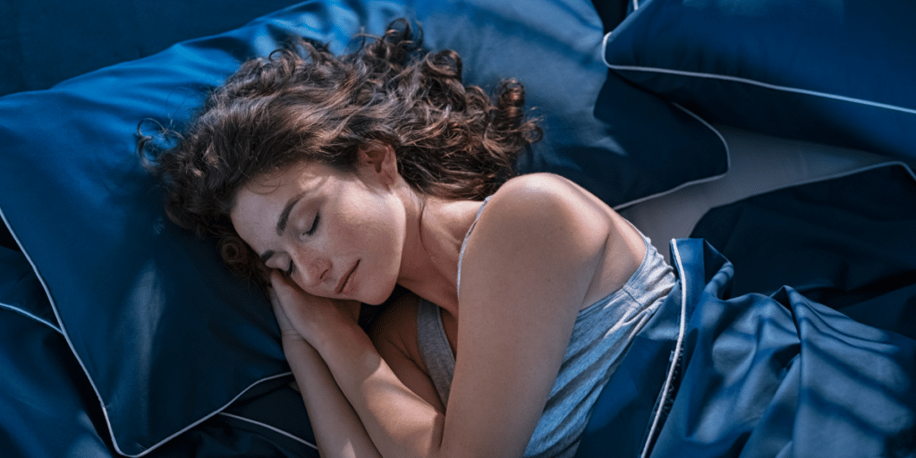 Woman sleeping in a bed. Getting enough sleep is essential for physical health and mental health. 