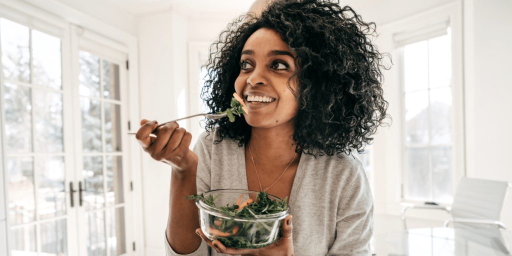 Woman eating a salad. Your client shouldn't reverse diet if they aren't already eating healthy.