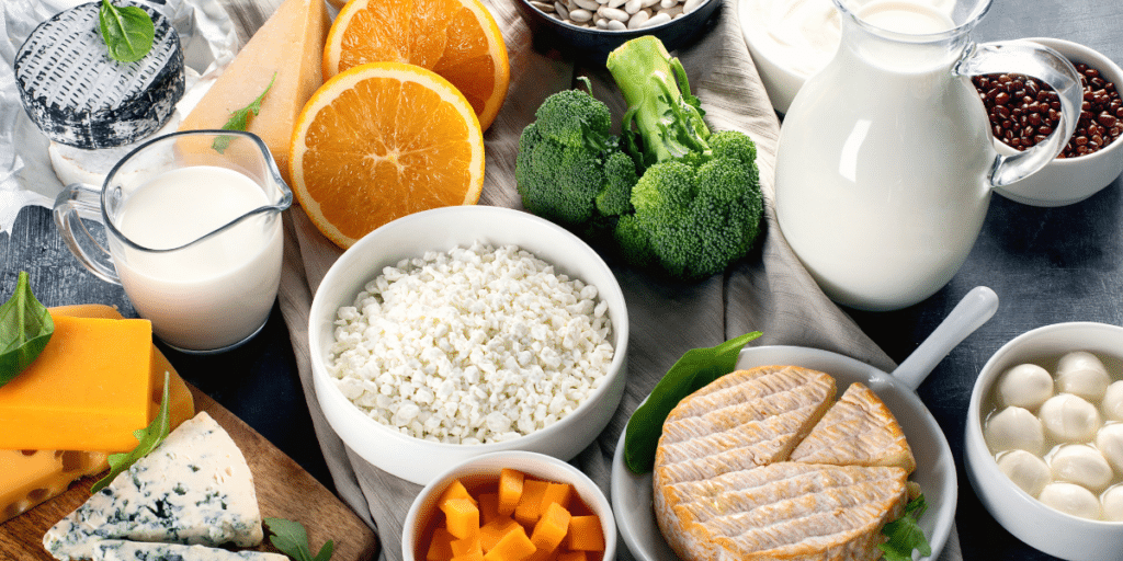 A lack of micronutrients is one way sleep quality affects health. Table covered in micronutrient-rich foods including beans, broccoli, cheeses, and oranges.